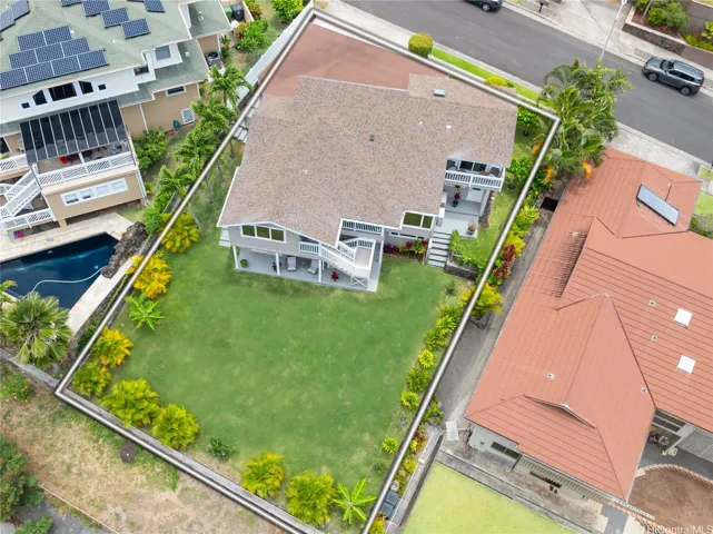 A sizable yard includes apple banana trees and easy to maintain landscaping.