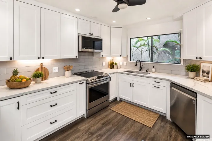 Kitchen features white quartz countertops and white cabinetry with soft-close drawers