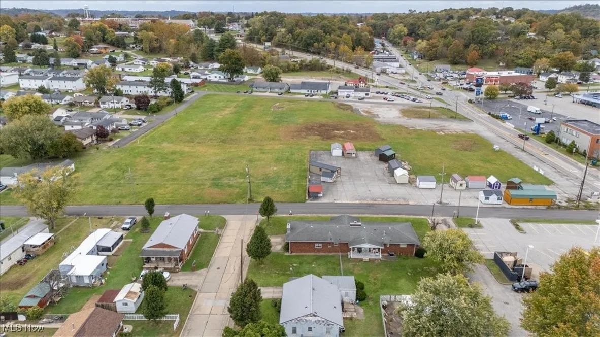 Aerial view of property and surrounding area featuring nearby suburban area