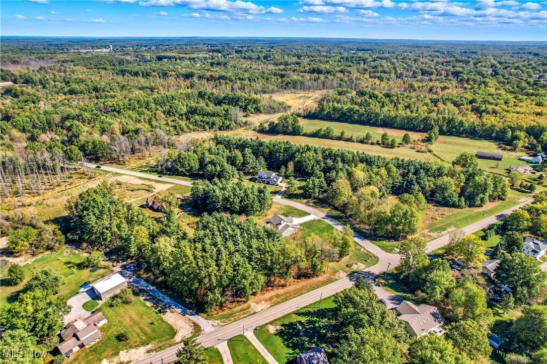 Aerial view of property and surrounding area featuring a forest