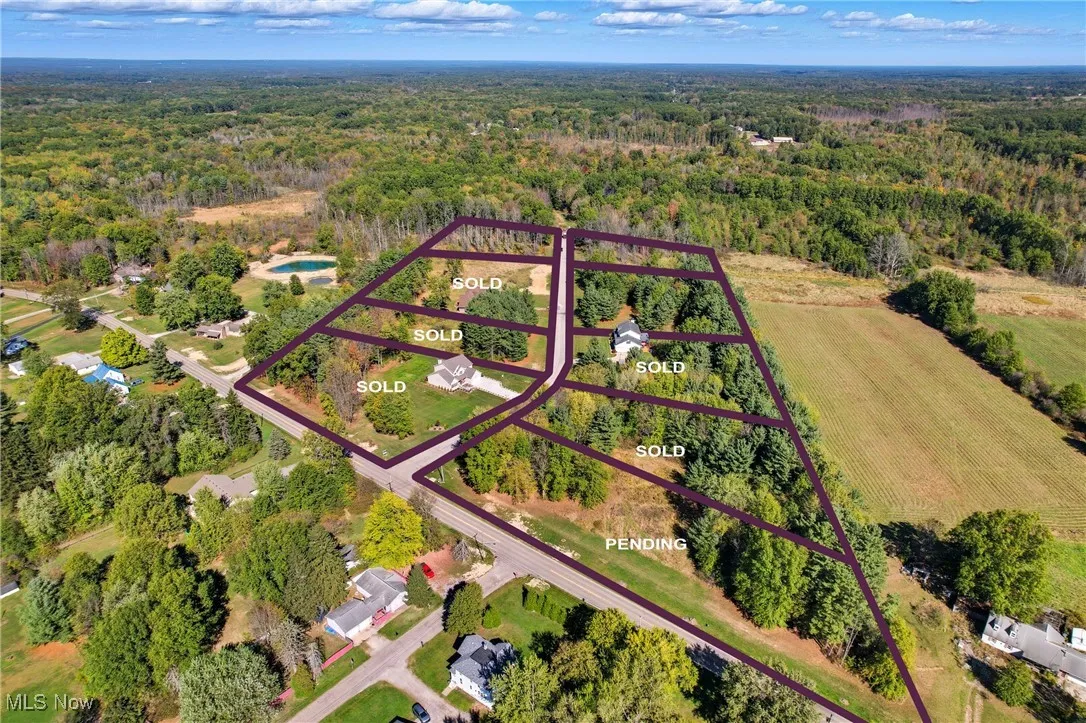Aerial overview of property's location with a heavily wooded area and property parcel outlined