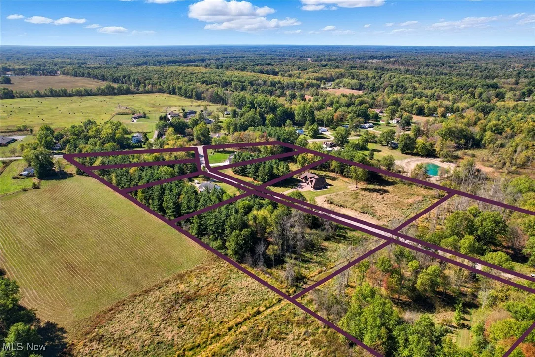 Aerial overview of property's location with a heavily wooded area and property boundaries highlighted