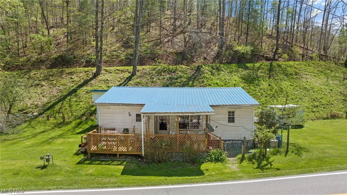 View of front facade with a front yard and wooden deck