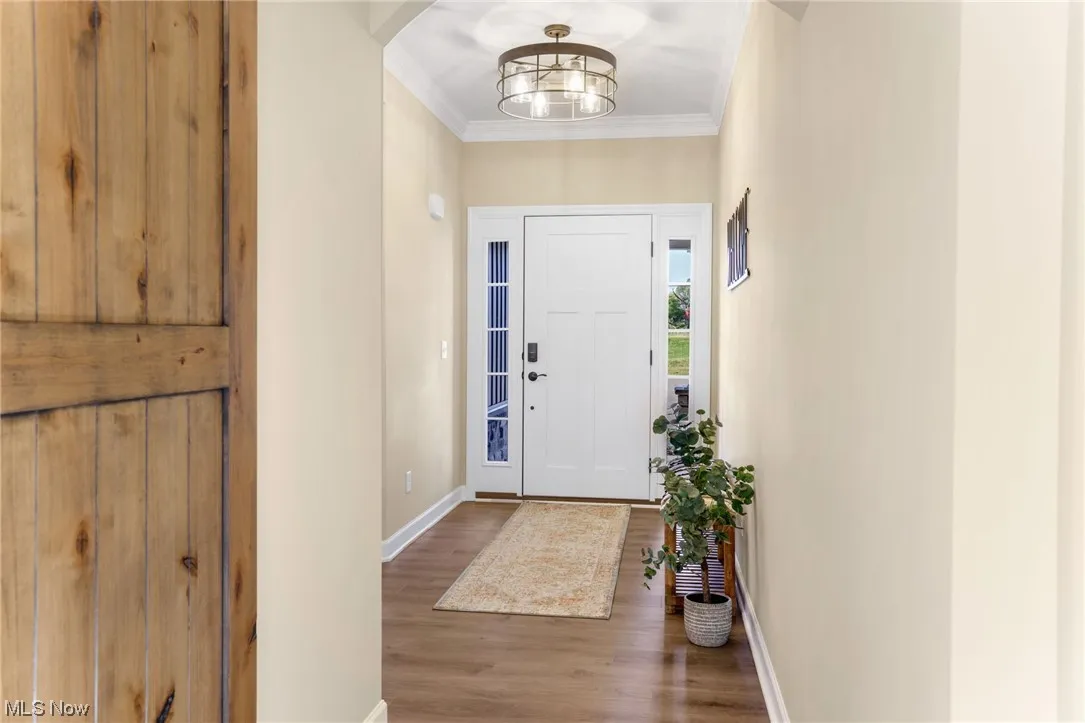 Wood floored entrance foyer with ornamental molding