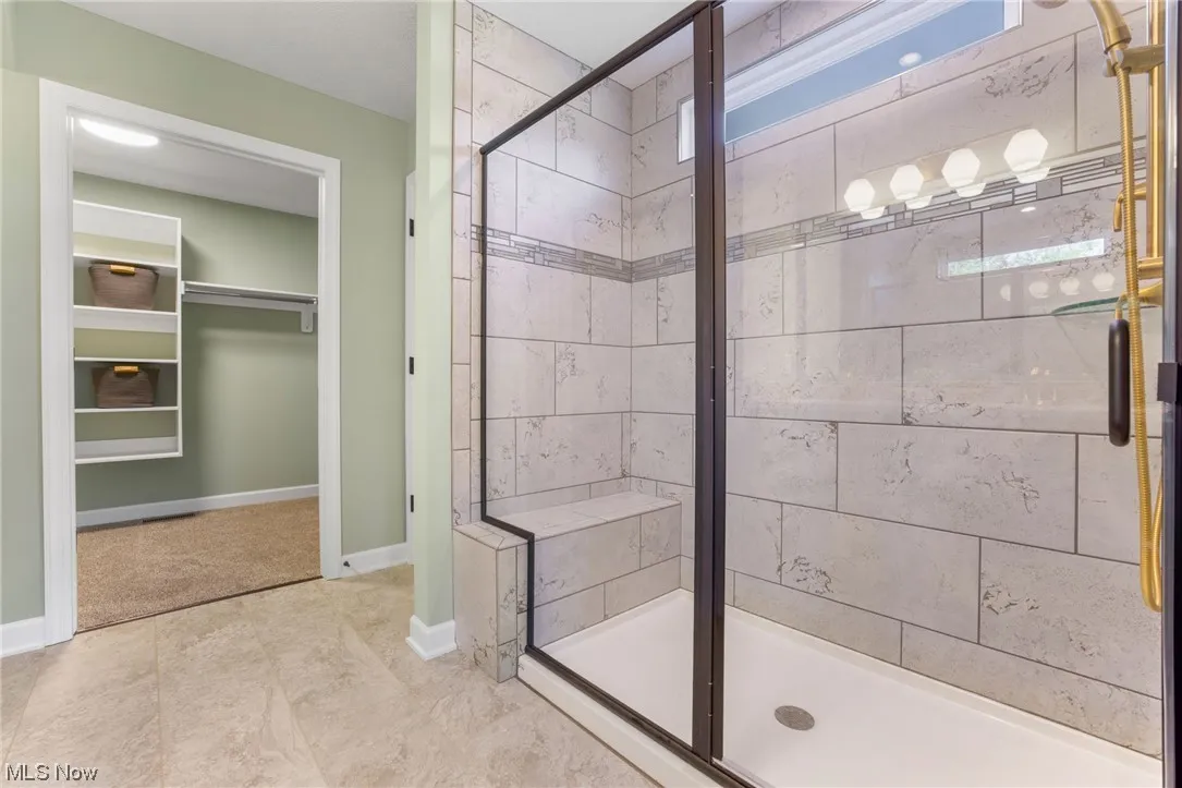 Bathroom featuring walk in shower and tile floors