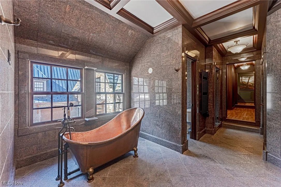 Carpeted home office featuring coffered ceiling and crown molding