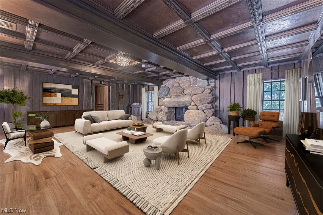 Hardwood floored living room featuring coffered ceiling, a fireplace, wooden walls, and beamed ceiling