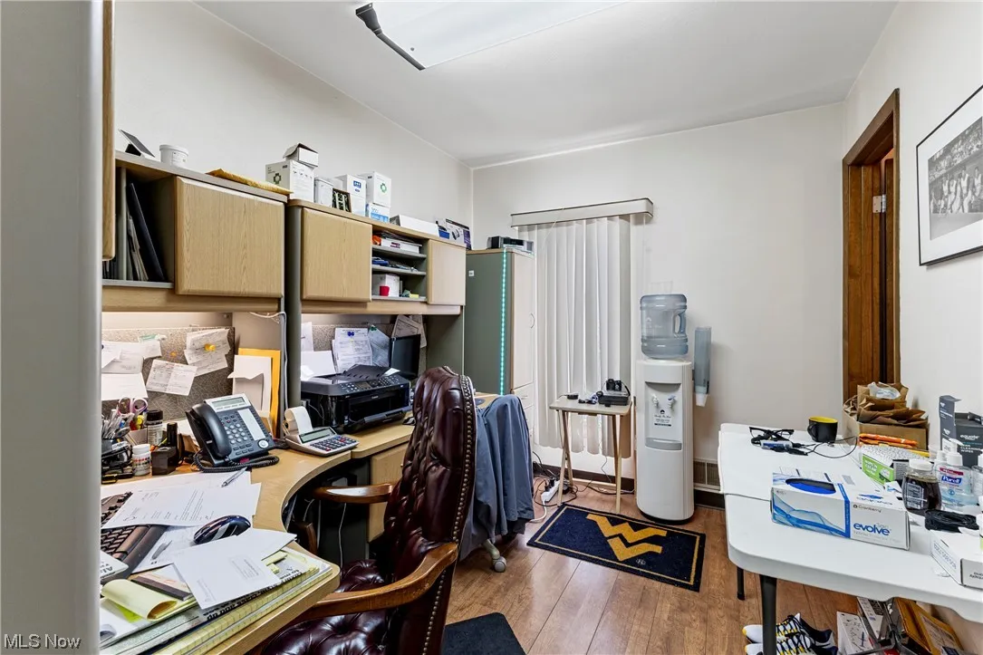 Office space with dark hardwood / wood-style floors