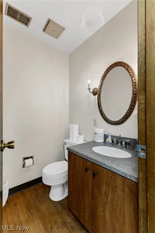 Bathroom featuring toilet, hardwood / wood-style floors, and large vanity