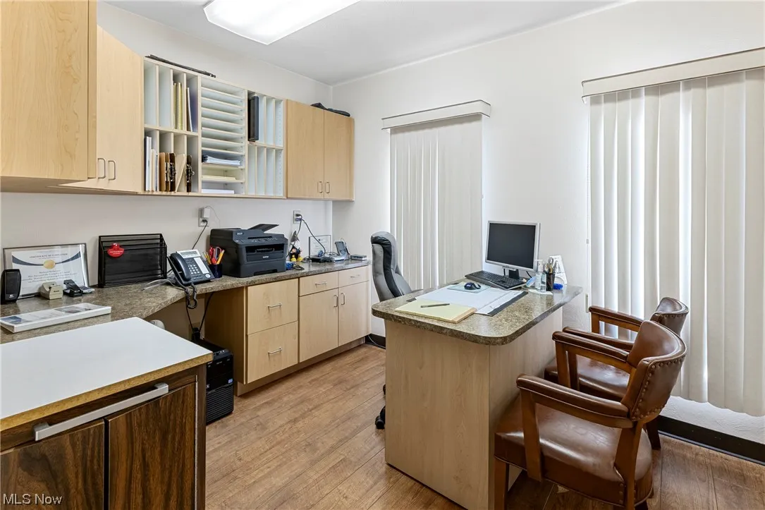 Office space featuring built in desk and light hardwood / wood-style flooring