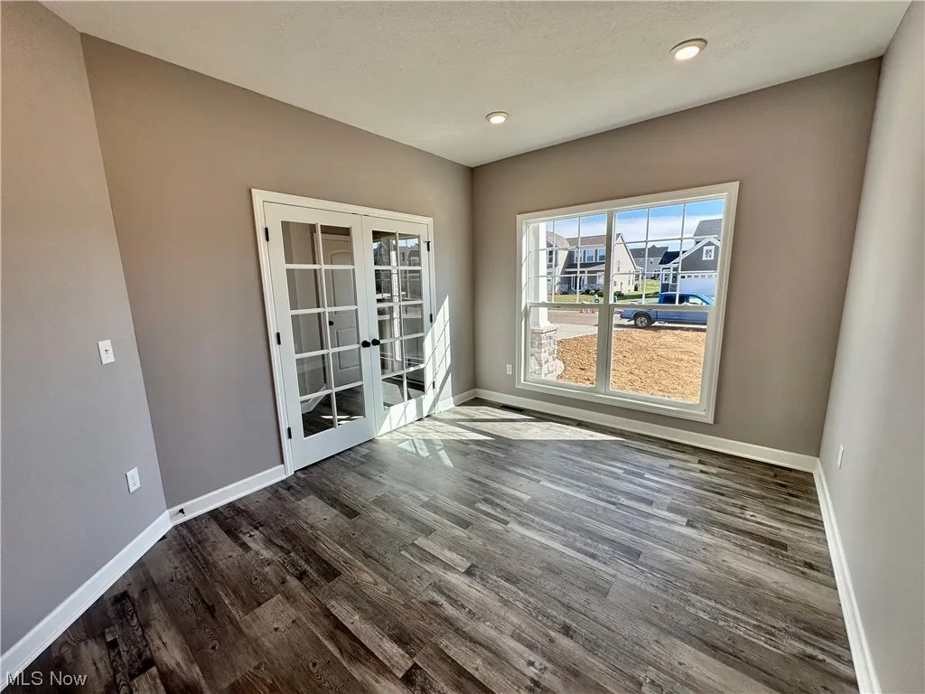 Spare room featuring dark wood-type flooring and french doors