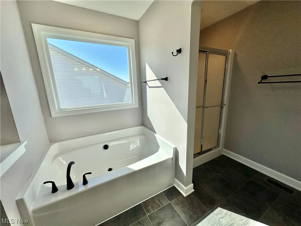Bathroom with tile flooring and plus walk in shower