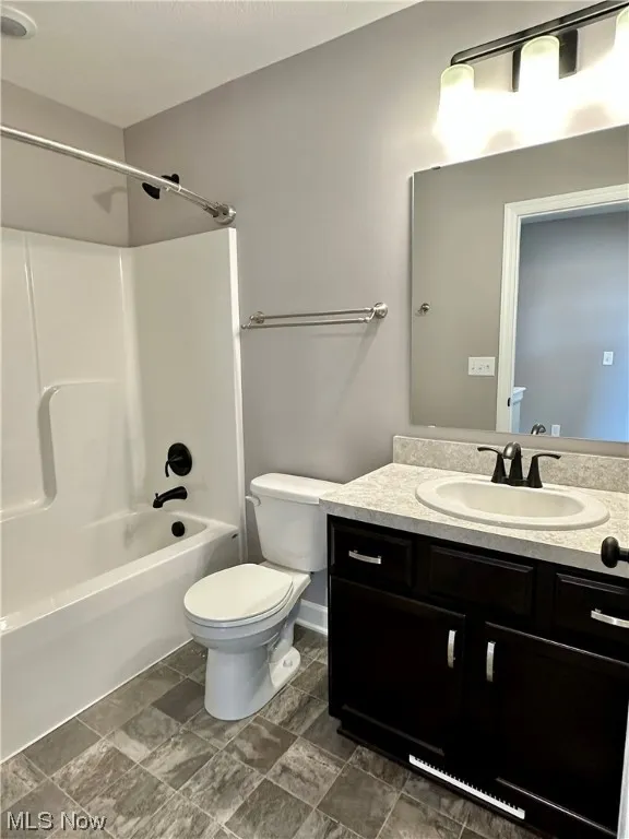 Full bathroom featuring vanity, toilet, tile floors, and shower / bath combination