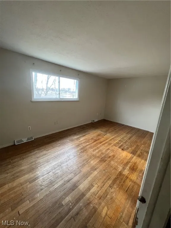 Unfurnished room with hardwood / wood-style floors