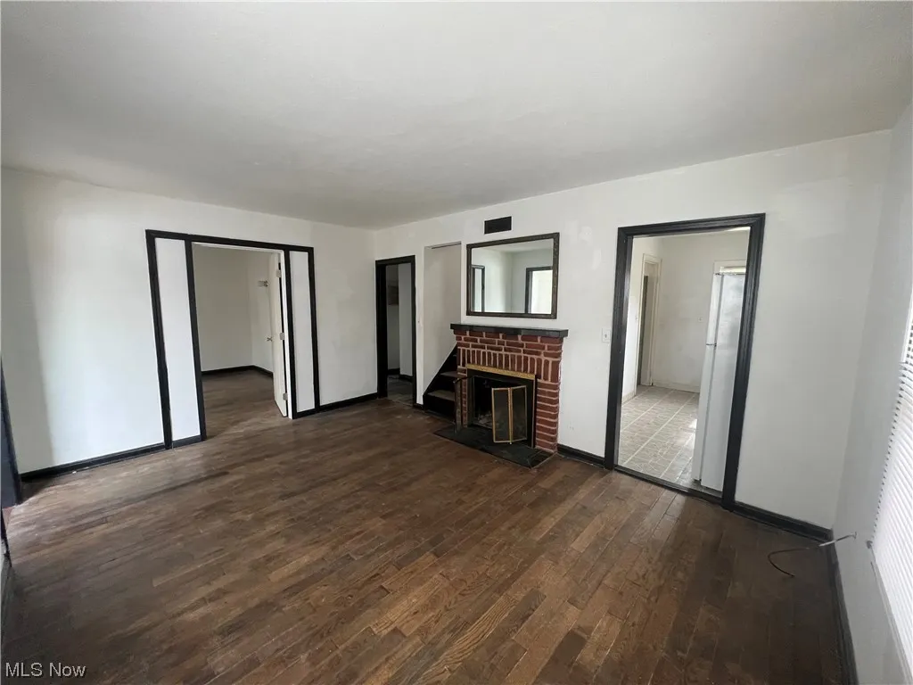 Unfurnished living room featuring dark hardwood / wood-style floors and a fireplace