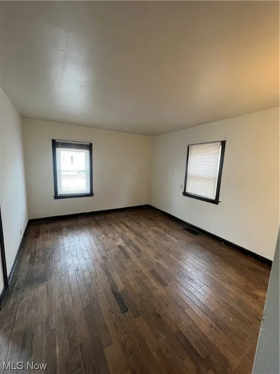 Unfurnished room featuring dark hardwood / wood-style flooring