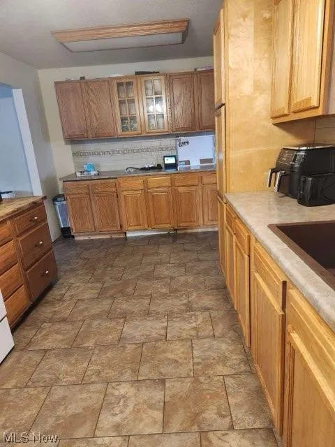 Kitchen featuring tasteful backsplash and tile flooring