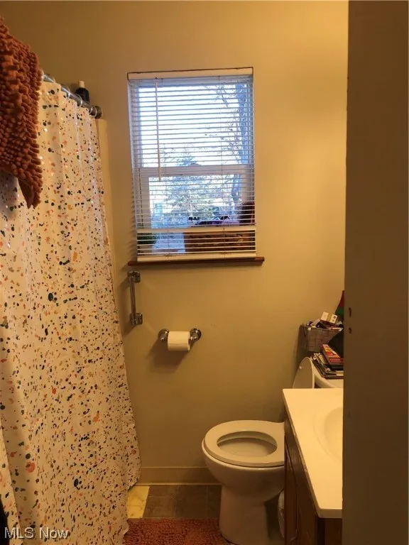 Bathroom with toilet, tile floors, and vanity