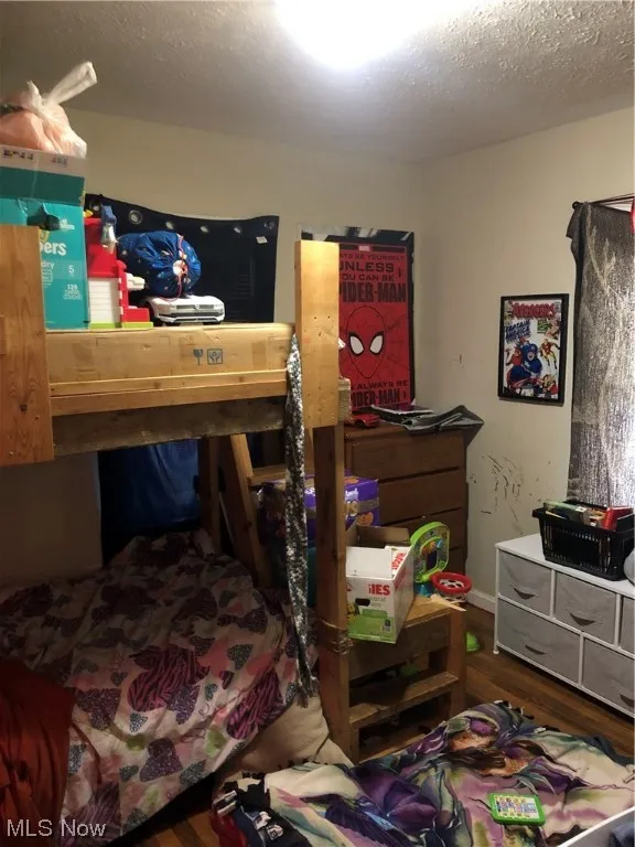 Bedroom with dark wood-type flooring and a textured ceiling