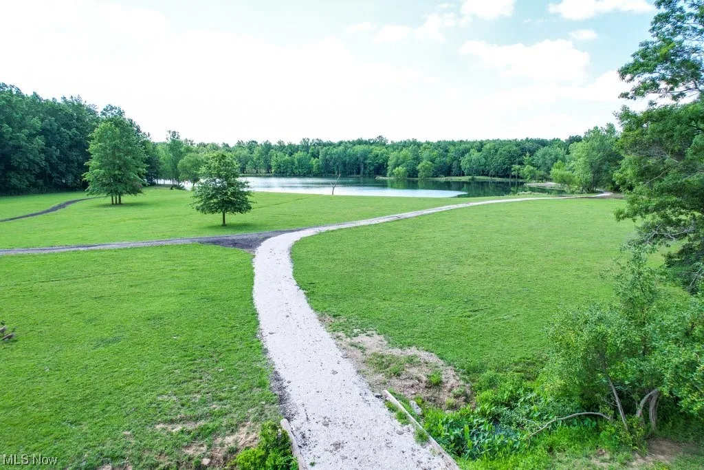 View of property's community with a water view and a yard