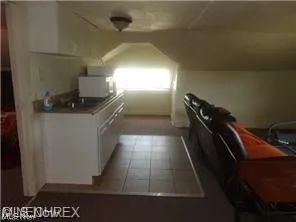 Kitchen with light tile floors and white cabinetry