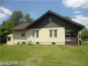 View of side of home with a lawn