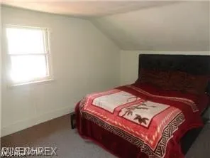 Carpeted bedroom featuring vaulted ceiling