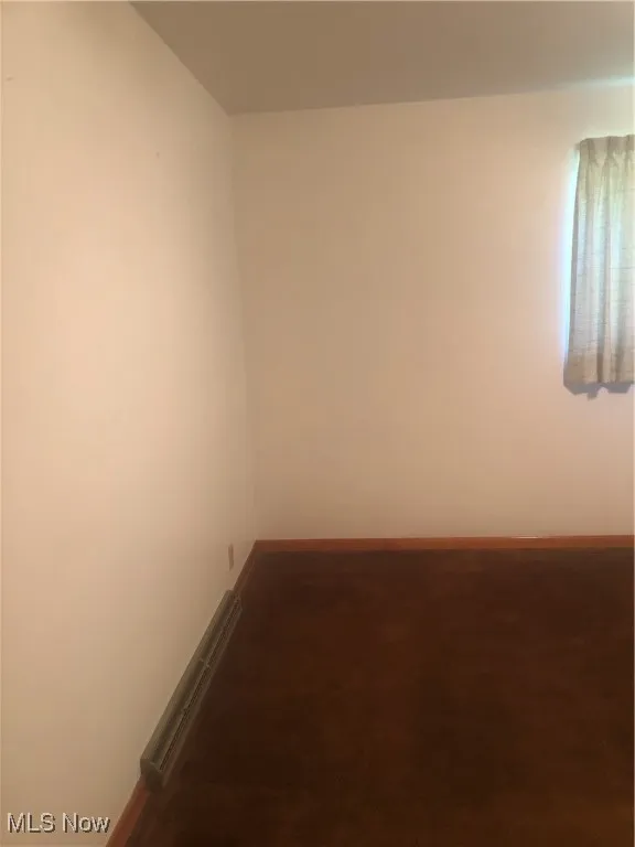 Carpeted empty room with baseboards