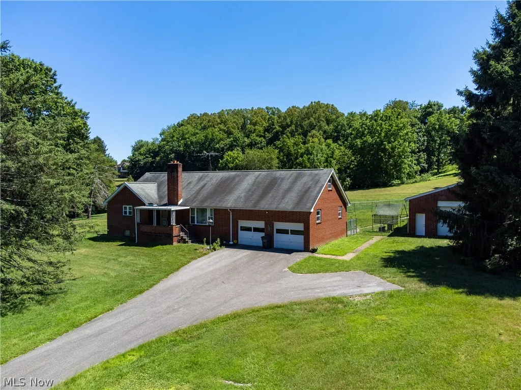 Single story home with a garage and a front lawn