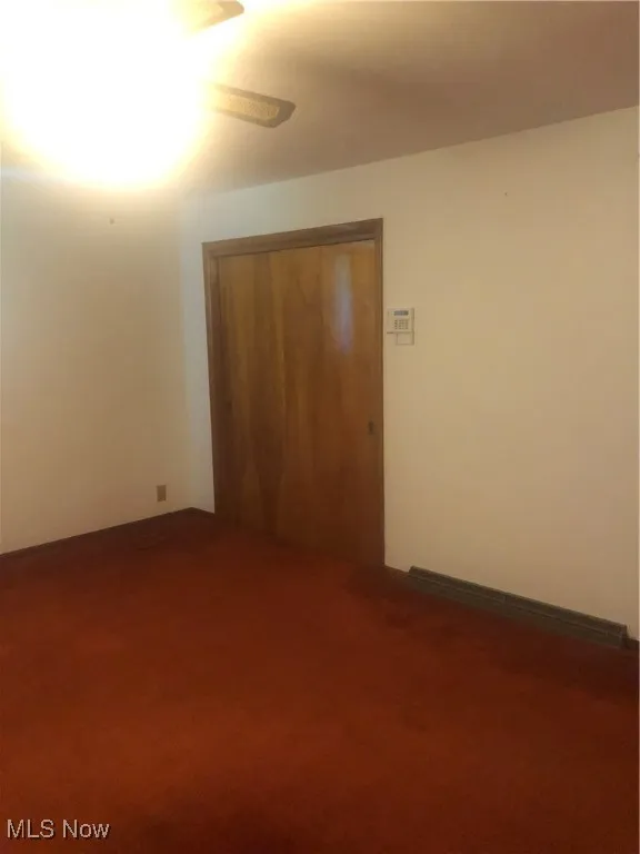 Spare room featuring carpet floors and ceiling fan