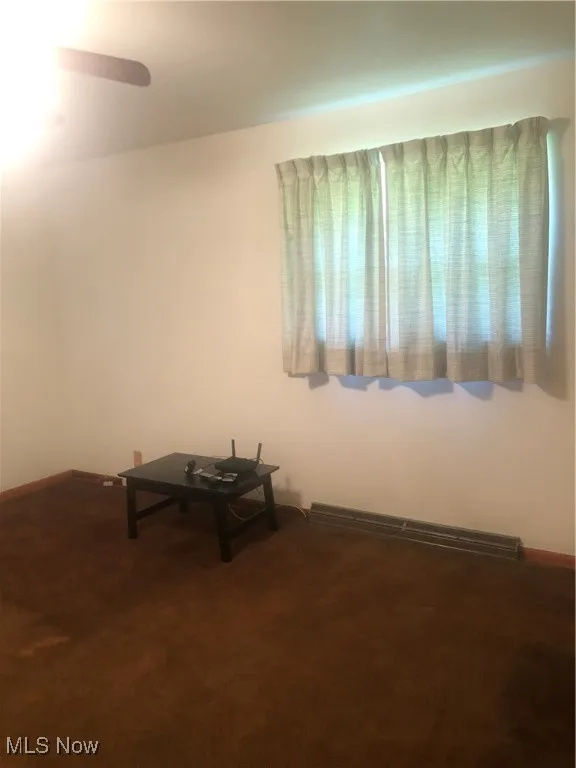Unfurnished room with a baseboard radiator and carpet flooring