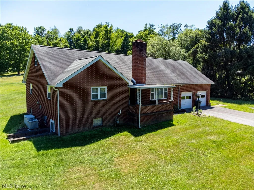 View of front of property featuring cooling unit and a front yard