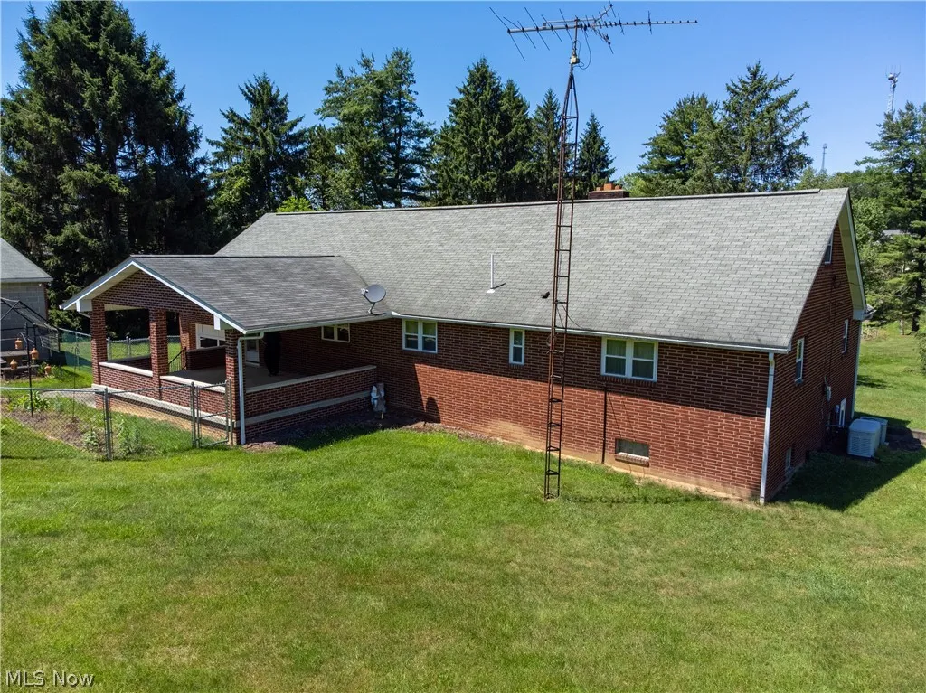 Back of property with a yard and central AC unit