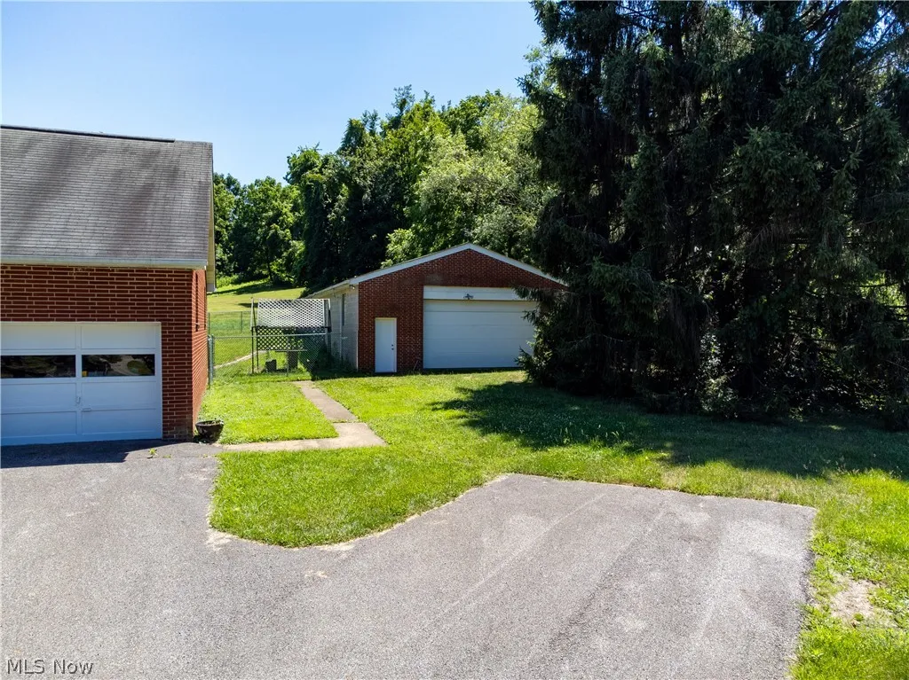 View of yard with a garage and an outbuilding