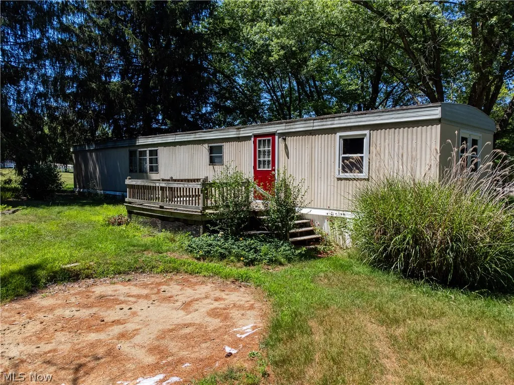 Manufactured / mobile home featuring a front yard and a wooden deck