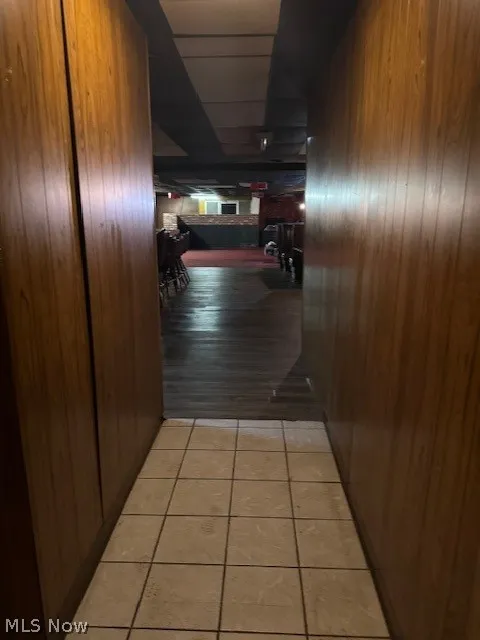 Corridor with wood walls and light tile floors