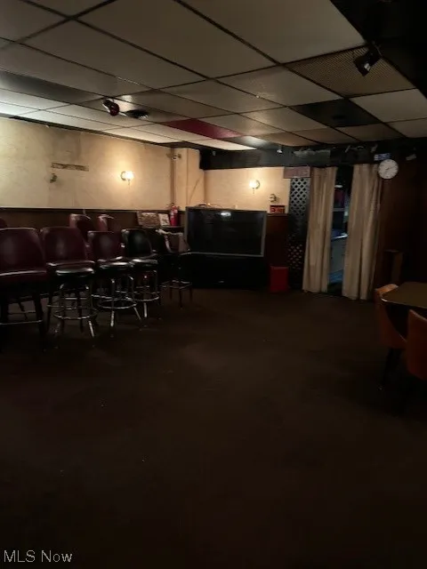 Basement featuring indoor bar and a paneled ceiling