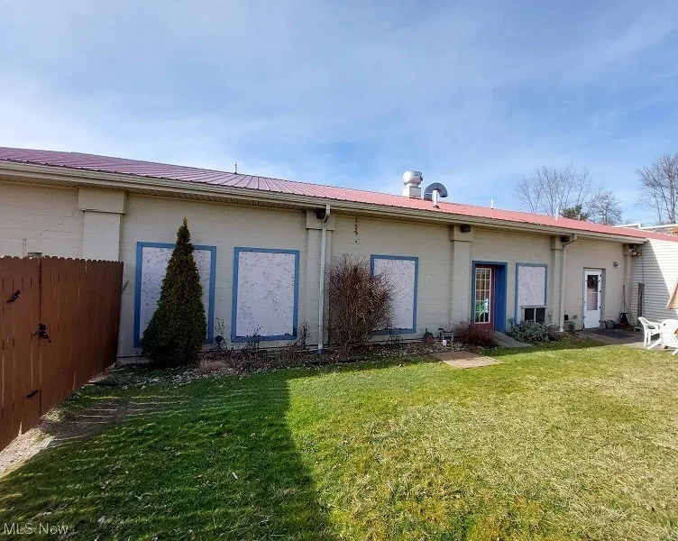 Back of property featuring a lawn