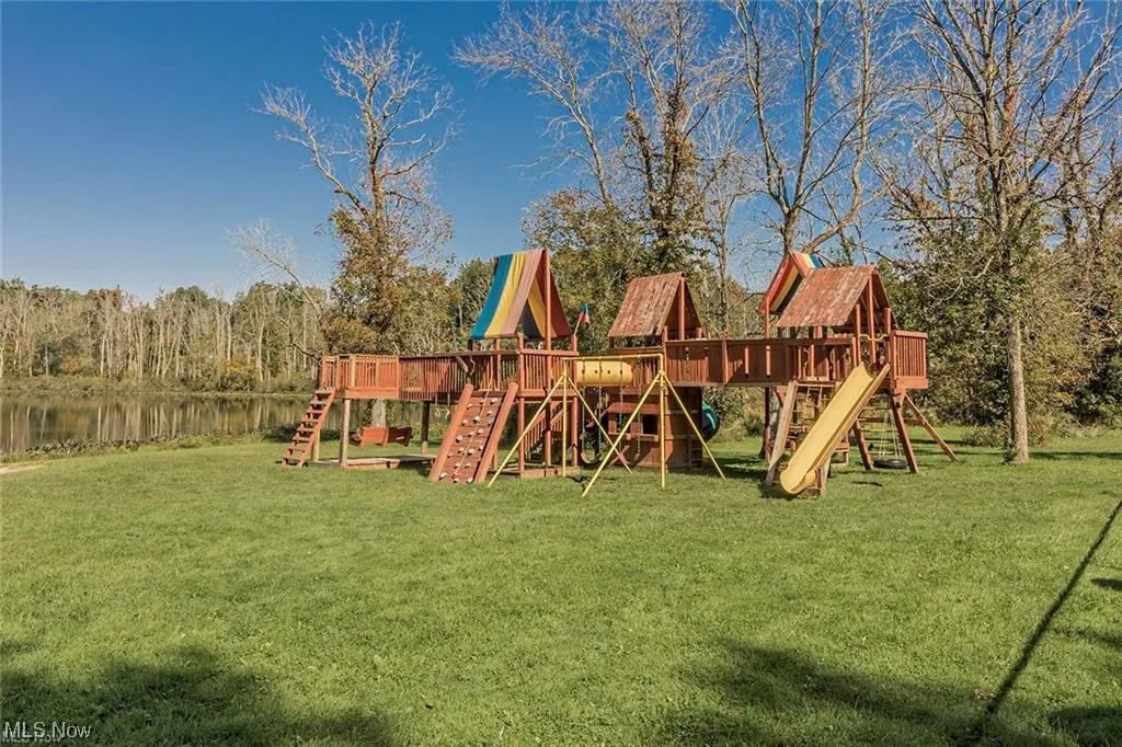 View of jungle gym featuring a yard and a water view