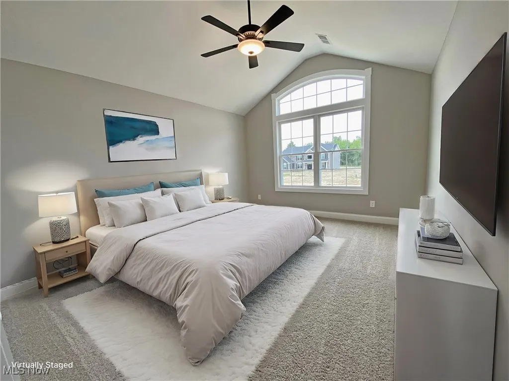 Bedroom featuring vaulted ceiling, light colored carpet,  ceiling fan and its own Private Bathroom