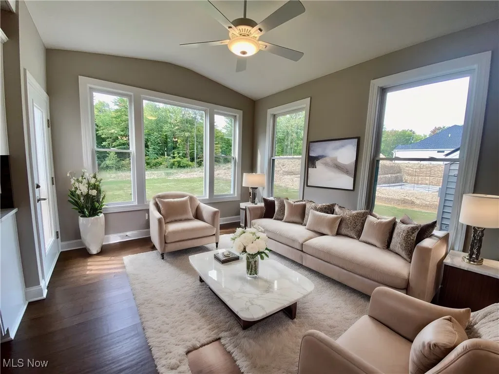 Sunroom featuring vaulted ceiling, ceiling fan, ornate columns, and hardwood flooring