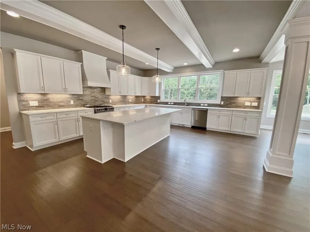 Kitchen featuring appliances with stainless steel finishes, white cabinetry, and custom exhaust hood