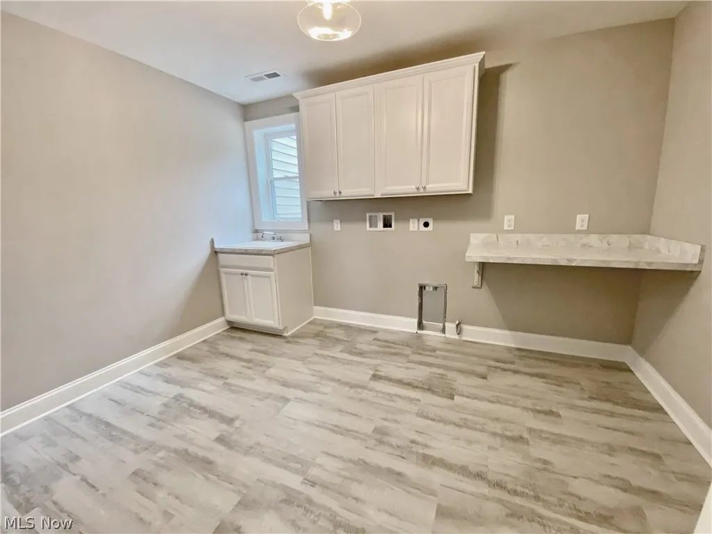 2nd Floor Laundry area featuring hookup for a washing machine, electric dryer hookup, cabinets, and light flooring