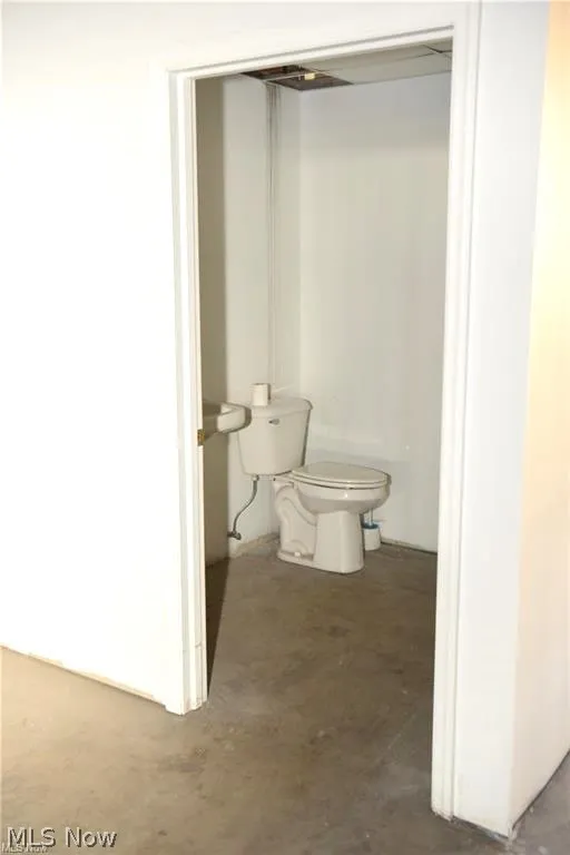 Bathroom featuring toilet and concrete flooring