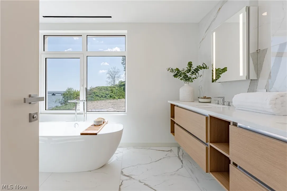 Bathroom with tile flooring, vanity, and a washtub
