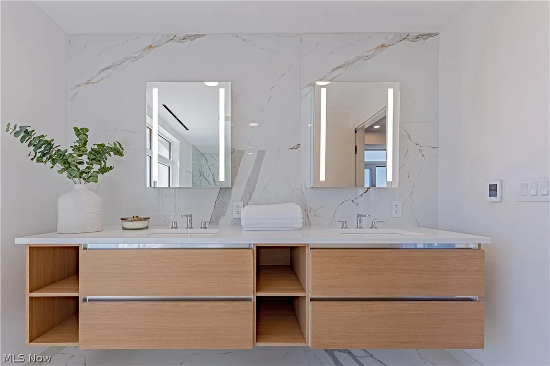 Bathroom featuring tile floors, tasteful backsplash, and double sink vanity