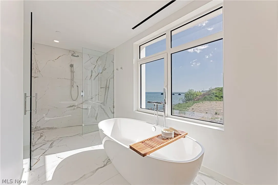 Bathroom featuring tile flooring, a healthy amount of sunlight, and a water view