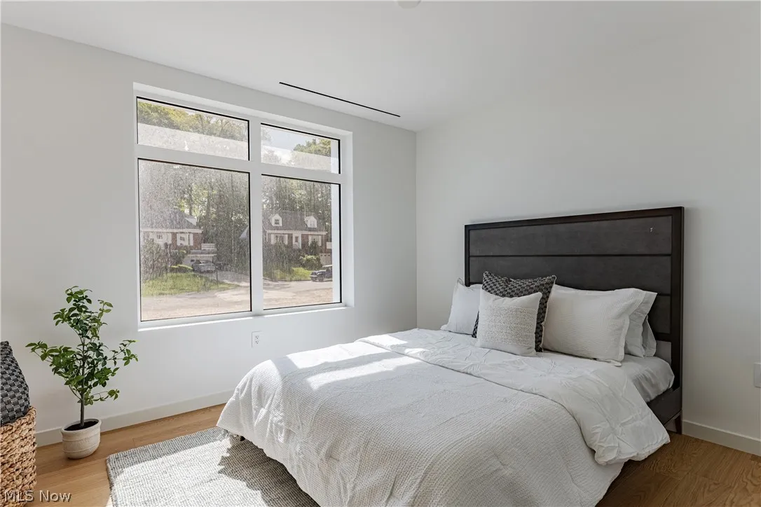 Bedroom with multiple windows and light hardwood / wood-style floors