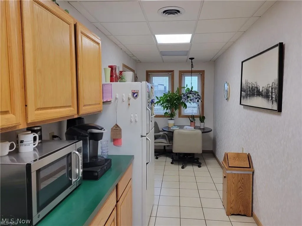 Shared kitchenette connects directly to the rear office and common hallway