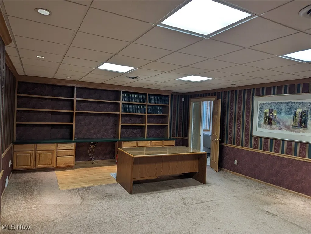 Carpeted office with built in book shelves & desk